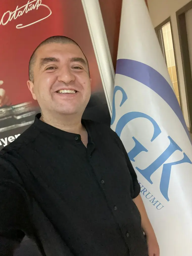 SGK kurum flaması önünde.